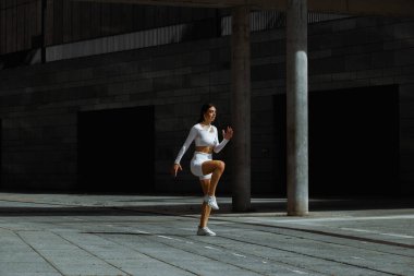 Sportif kız sokakta fonksiyonel eğitimle performans sergiliyor.