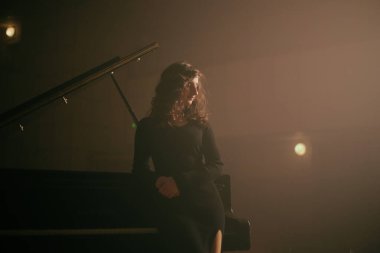 Konser salonunda piyano çalan kadın.