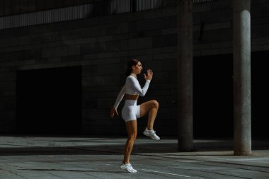 Sportif kız sokakta fonksiyonel eğitimle performans sergiliyor.