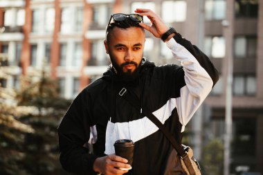 Genç adam gündüz vakti büyük şehrin ortasında yürüyor.