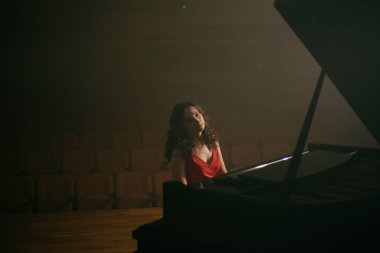 Konser salonunda piyano çalan kadın.