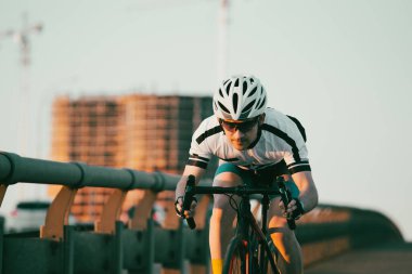 Şehirde bisiklete binen genç adam, gündüz manzaralı. 