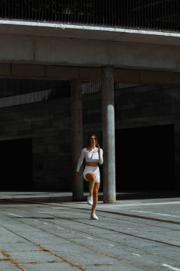 Sportif kız sokakta fonksiyonel eğitimle performans sergiliyor.