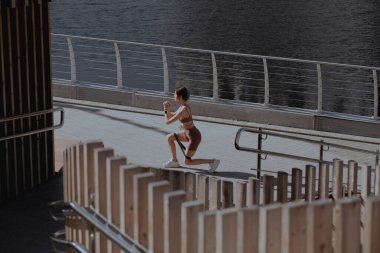 Genç bir kadın şehrin ortasında dışarıda egzersiz yapıyor.