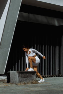 Sportif kız sokakta fonksiyonel eğitimle performans sergiliyor.