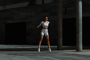 Sportif kız sokakta fonksiyonel eğitimle performans sergiliyor.