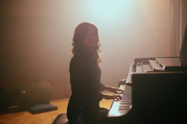 Konser salonunda piyano çalan kadın.