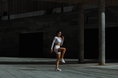 Sportif kız sokakta fonksiyonel eğitimle performans sergiliyor.