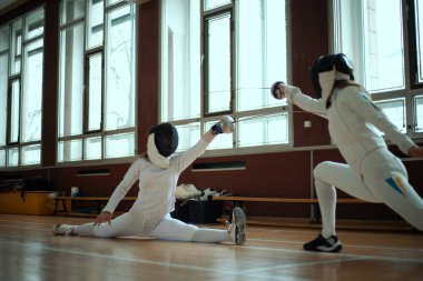 Eskrim sporu. Salonda iki kız eskrim eğitimi..