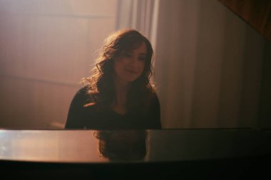 Konser salonunda piyano çalan kadın.