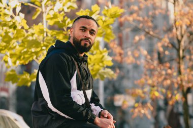 Genç adam gündüz vakti büyük şehrin ortasında yürüyor.