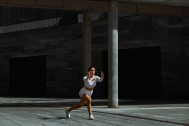 Sportif kız sokakta fonksiyonel eğitimle performans sergiliyor.