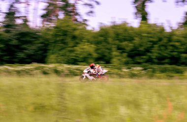 Bir motosiklet yarışçısı motosiklet pistinde hızlı sürüyor..