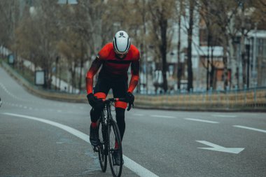 Şehirde bisiklete binen genç adam, gündüz manzaralı. 