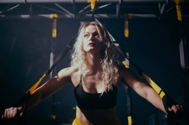 Spor salonunda kıvırcık saçlı sarışın genç bir kadın.