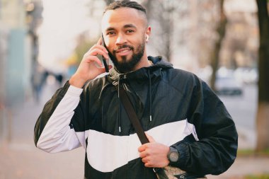 Genç adam gündüz vakti büyük şehrin ortasında yürüyor.