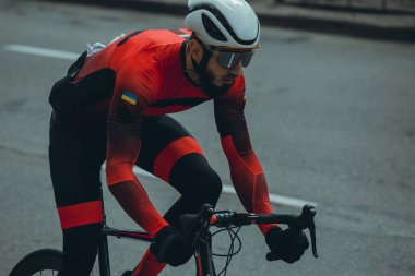 Şehirde bisiklete binen genç adam, gündüz manzaralı. 