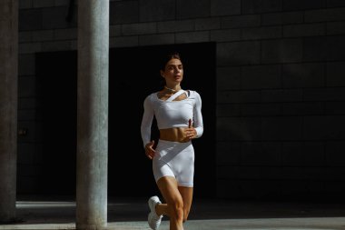 Sportif kız sokakta fonksiyonel eğitimle performans sergiliyor.