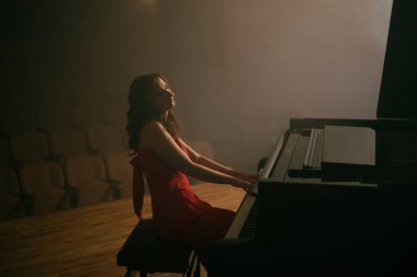 Konser salonunda piyano çalan kadın.