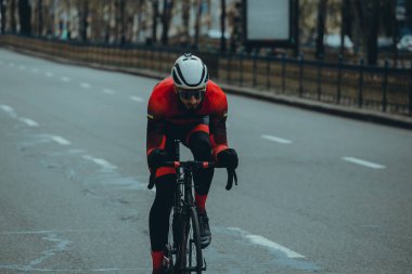 Şehirde bisiklete binen genç adam, gündüz manzaralı. 