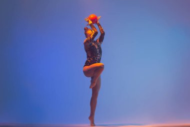 Ritmik jimnastik iş başında. Ritmik jimnastikçi kadın stüdyoda dans ediyor..