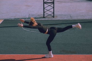 Genç bir kadın dışarıda spor yapıyor.