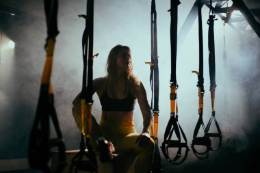 Spor salonunda kıvırcık saçlı sarışın genç bir kadın.