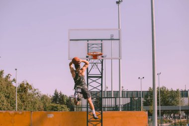 Erkek basketbolcu ringe top atıyor