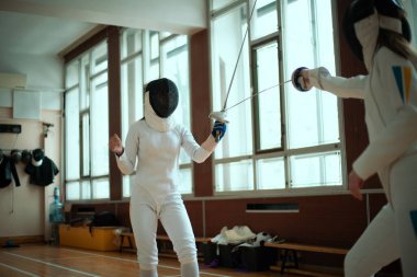 Eskrim sporu. Salonda iki kız eskrim eğitimi..