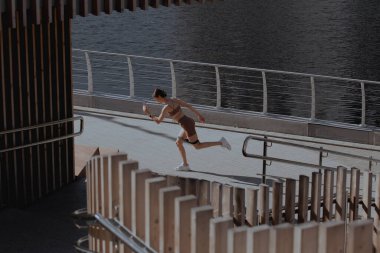 Genç bir kadın şehrin ortasında dışarıda egzersiz yapıyor.