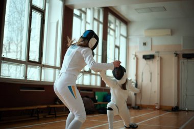 Eskrim sporu. Salonda iki kız eskrim eğitimi..