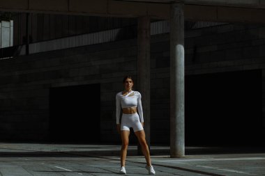 Sportif kız sokakta fonksiyonel eğitimle performans sergiliyor.