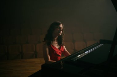 Konser salonunda piyano çalan kadın.