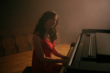 Konser salonunda piyano çalan kadın.