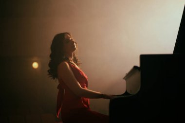 Konser salonunda piyano çalan kadın.