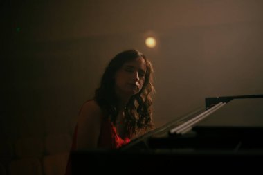 Konser salonunda piyano çalan kadın.