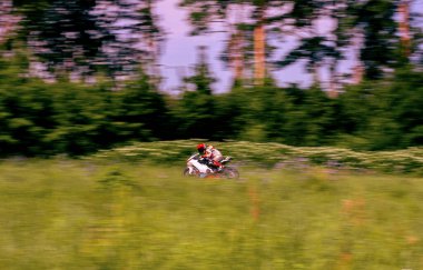 Bir motosiklet yarışçısı motosiklet pistinde hızlı sürüyor..