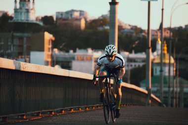 Şehirde bisiklete binen genç adam, gündüz manzaralı. 