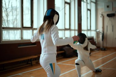 Eskrim sporu. Salonda iki kız eskrim eğitimi..