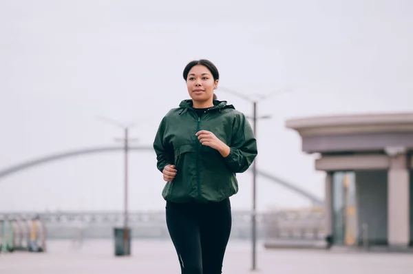 若い女性が屋外でトレーニングしています 都市で走っているスポーティな女の子 — ストック写真