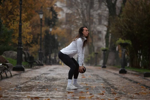 雨の公園で訓練する若い女性 屋外で運動する女性のジョギング — ストック写真