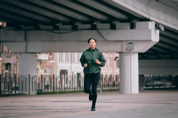 若い女性が屋外でトレーニングしています 都市で走っているスポーティな女の子 — ストック写真