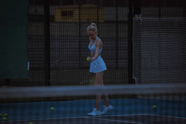 Woman tennis player trains on the tennis court