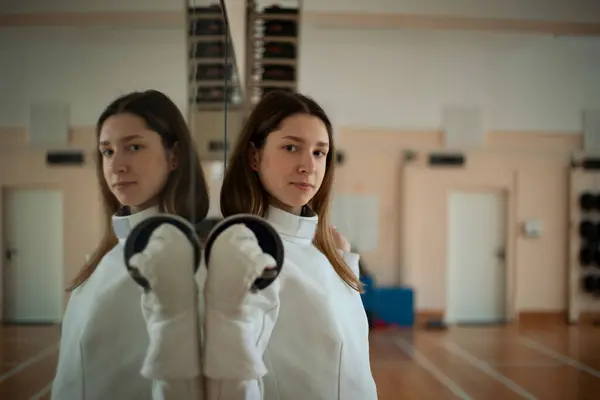 Fencing sport. Beauty female fencer training in hall.