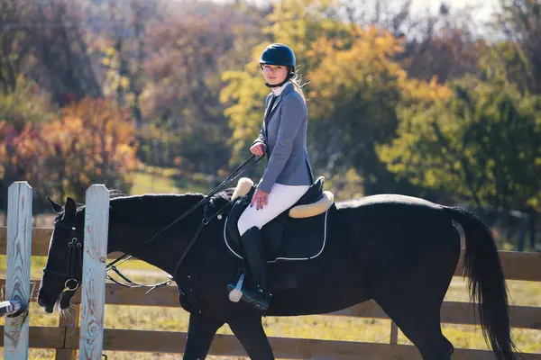 Güzel kız ata biniyor.