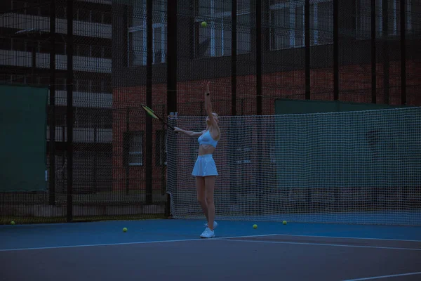 Woman tennis player trains on the tennis court