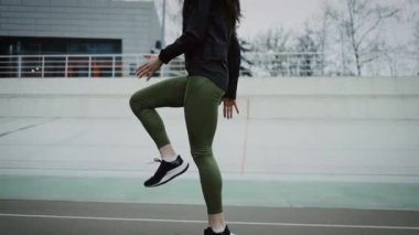 Genç atletik kız stadyumda egzersiz yapıyor..