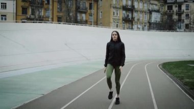 Genç atletik kız stadyumda egzersiz yapıyor..