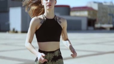 Genç atletik kız şehirde koşuyor. 