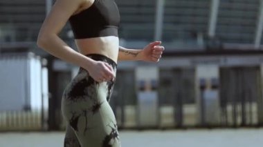 Genç atletik kız şehirde koşuyor. 